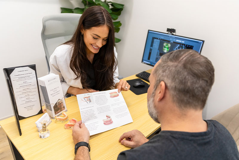 Dr. Mencini going over financing options for full mouth dental implant with matthew, her patient