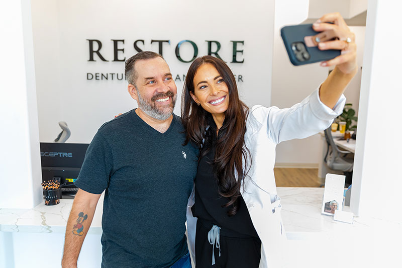 Dr. Mencini taking a selfie with one of her full mouth implant patients
